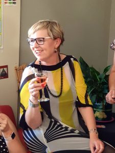 Emma Jacobs South African Artist holding glass of wine and smiling